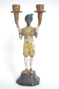 A cold painted bronze figurine of a blackamoor hol