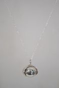 A silver pendant necklace strung with a silver bal