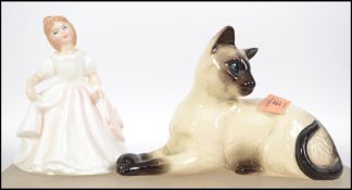 A Royal Doulton figurine of a cat being stamped to