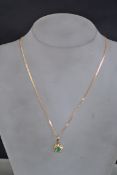 A 9ct gold, emerald and diamond pendant set to a 9