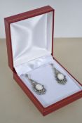 A pair of Art Deco style earrings set with a centr