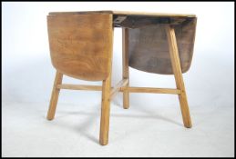 A retro beech and elm Ercol drop leaf dining table