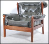 A 1970's teak and leather armchair. The teak frame