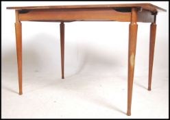 A 1970's retro teak wood dining table raised on ta