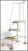 A mid century Industrial factory ' picking ' ladder of metal form with handle and half moon feet