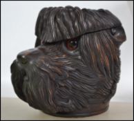 A large and impressive carved black forest tobacco jar in the form of a dog with glass eyes and