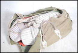 A large cricket club bag being complete with pads,