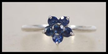A 14ct white gold daisy ring set with blue stones