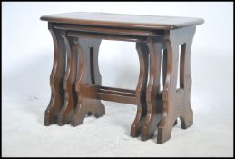 An Ercol elm wood Old Colonnial style nest of tabl