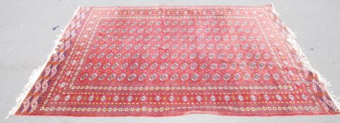 A large carpet rug having a russet red ground with