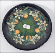 A William Moorcroft plate being marked to the back