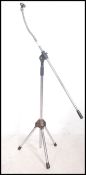 A vintage mid 20th century tubular adjustable microphone stand, standing on tripod feet and having