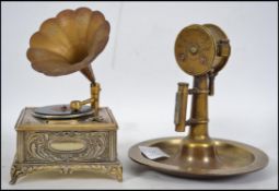 An early 20th century novelty brass cigar cutter, match strike and ashtray in the form of a ships