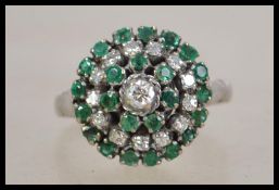 An 18ct white gold emerald and diamond cluster dre