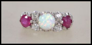 A ladies silver ring being inset with garnet and o