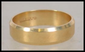 A hallmarked 18ct gold band ring with chamfered ed