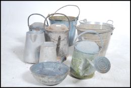 A collection of vintage metal watering cans to inc