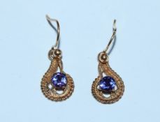 A pair of 9ct gold earrings set with a purple ston