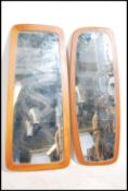 A pair of retro framed teak wood wall mirrors of a