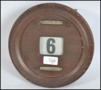 A 1930's Art Deco golden oak circular wall calenda