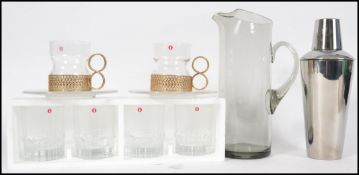 A vintage style cocktail shaker together with a se