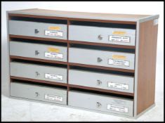 A 1970's retro brushed metal letterbox having twin upright sections with brushed aluminium lift up