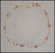 A ladies 14ct gold and ruby bracelet complete in t