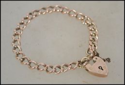 A hallmarked 9ct gold bracelet with heart lock. Ha