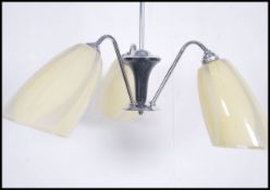 A retro 1970's glass and chrome ceiling light chandelier with conical glass shades on shaped