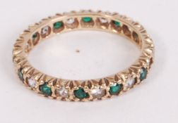 A hallmarked 9ct gold eternity ring set with green