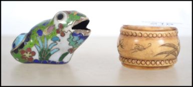 A vintage 19th century bone snuff box with a scrimshaw design along with a Oriental cloisonne frog.