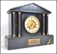 A Victorian black slate mantle clock, with columns