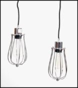 A pair of industrial vintage style polished metal ceiling inspection lights. Each light fitted