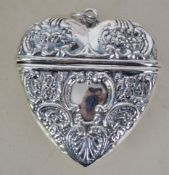 A silver heart shaped locket of decorative form co
