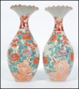 A pair of early 20th century Chinese baluster vases with fluted tops, decorated with foliate