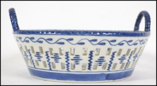 A 20th century Chinese blue and white ribbon edged, twin handled bowl decorated with flowers and