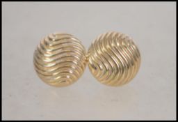 A pair of ladies 9ct gold earrings having a wave p