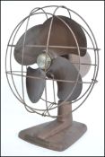 A vintage mid 20th century industrial metal desk fan having wired cage to front with notation for