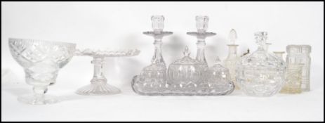 A collection of cut glass to include a dressing table set, candlesticks, cake stand, various vials