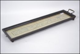 A 19th century hardwood twin handled glazed serving tray framing an antique Chinese silk embroidery.