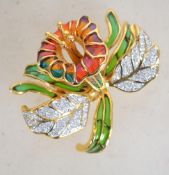 A gold tone Joan Rivers Plique a Jour and rhinestone set brooch in the form of a flower orchid