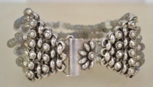 A sterling silver 925 and bead multi strand bracelet chain with floral motif to clasp. Weighs 64