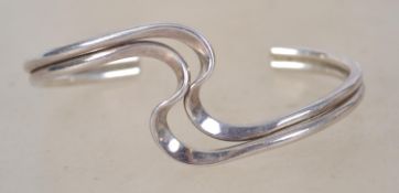 A sterling silver 925 twin bar bangle bracelet of crossover form. Weighs 22.9 grams and measures