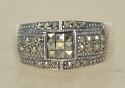 A sterling silver 925 and marcasite dress ring having a central marcasite grid with marcasite border