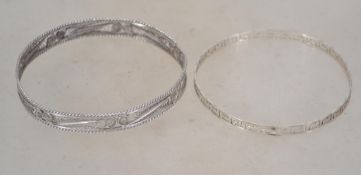 Two vintage silver bangles one in a Greek key pattern and one in filigree. Both unmarked and test as
