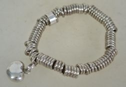 A sterling silver 925 wire expanding bracelet chain having silver hoops and a silver heart drop.