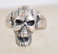 A sterling silver 925 highly detailed skull ring with hollow eye sockets, open jaw and bone