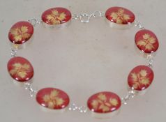 A contemporary silver bracelet having dried flowers set in resin. Marked 925 measures 20.5 cms