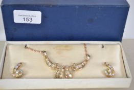 A vintage 1950s rhinestone necklace and earring set in original box being gold tone with aurora