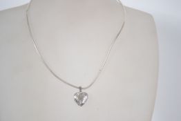 A sterling silver rigid snake link necklace chain having a heart drop locket pendant with leaf swirl
